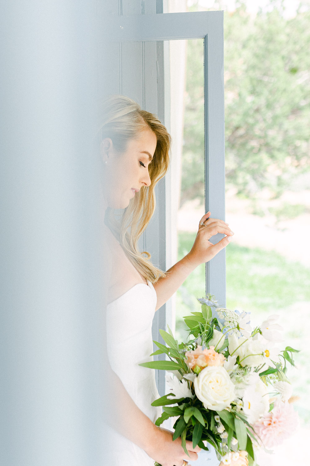 Bride peeks through a blue door.