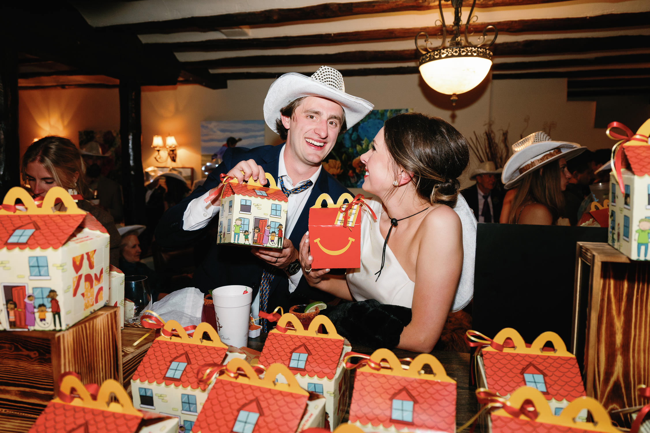 Wedding guests hold mcdondald's happy meals at afterparty