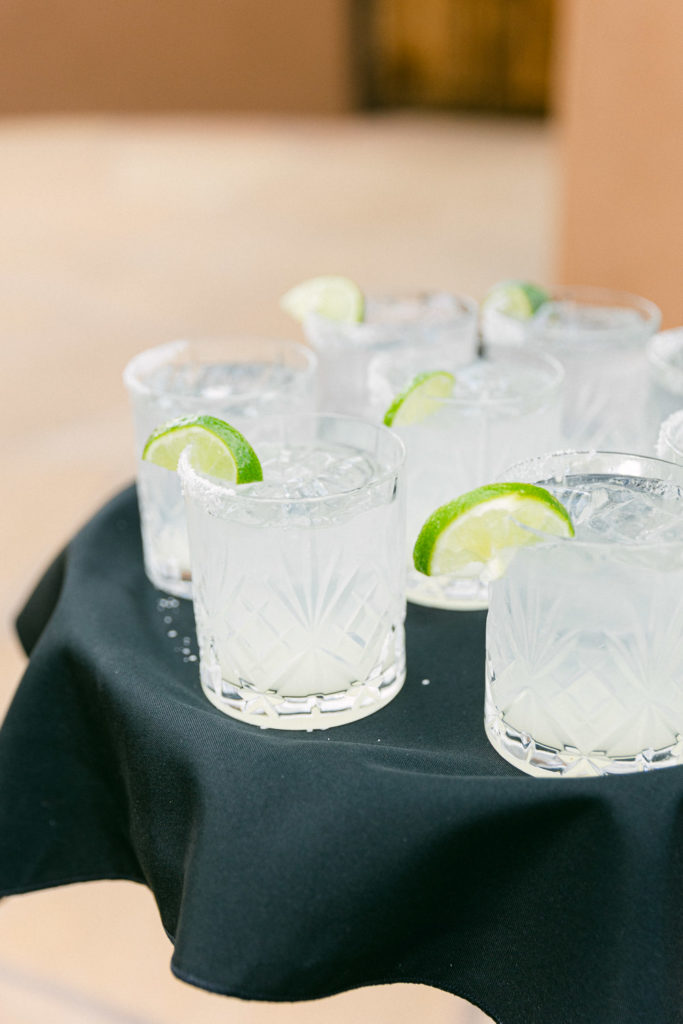 Tray of Margaritas with lime on the rim.