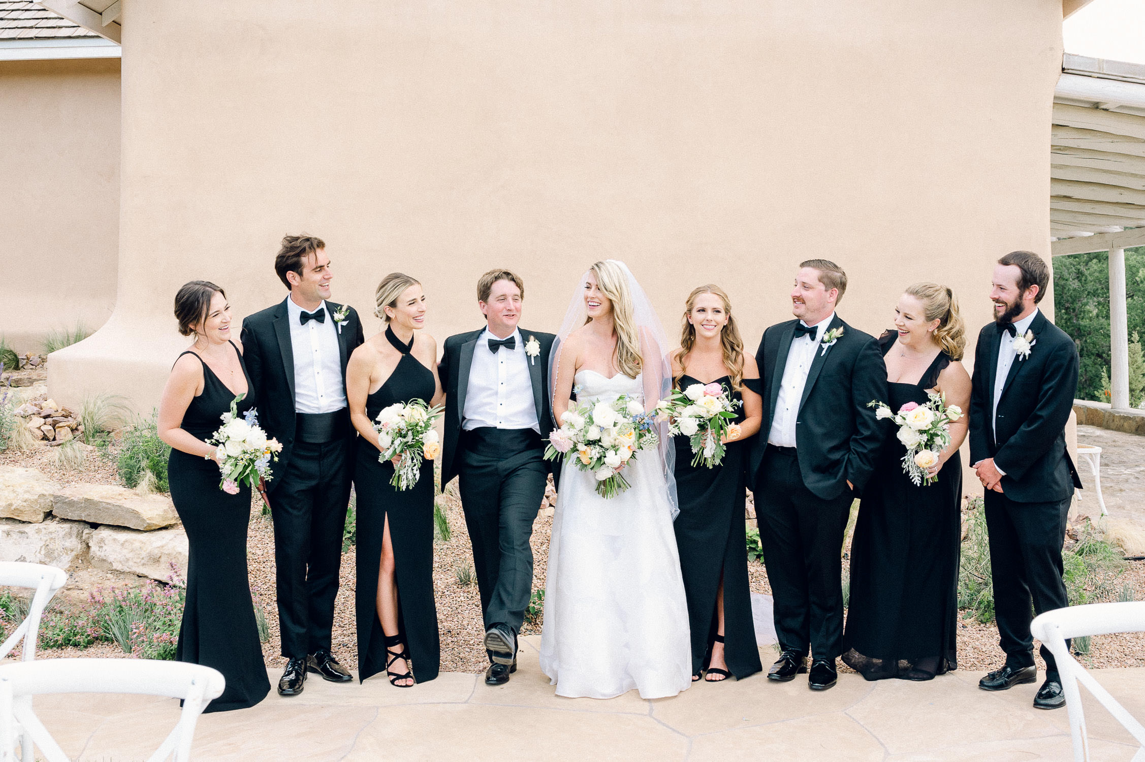 Candid wedding party photo in front of the chapel at Bishop's Lodge in Santa Fe.