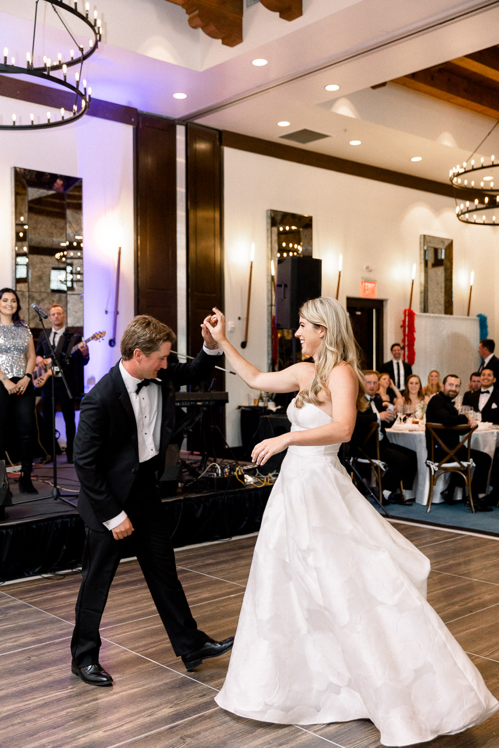 Groom spins bride around during their first dance.