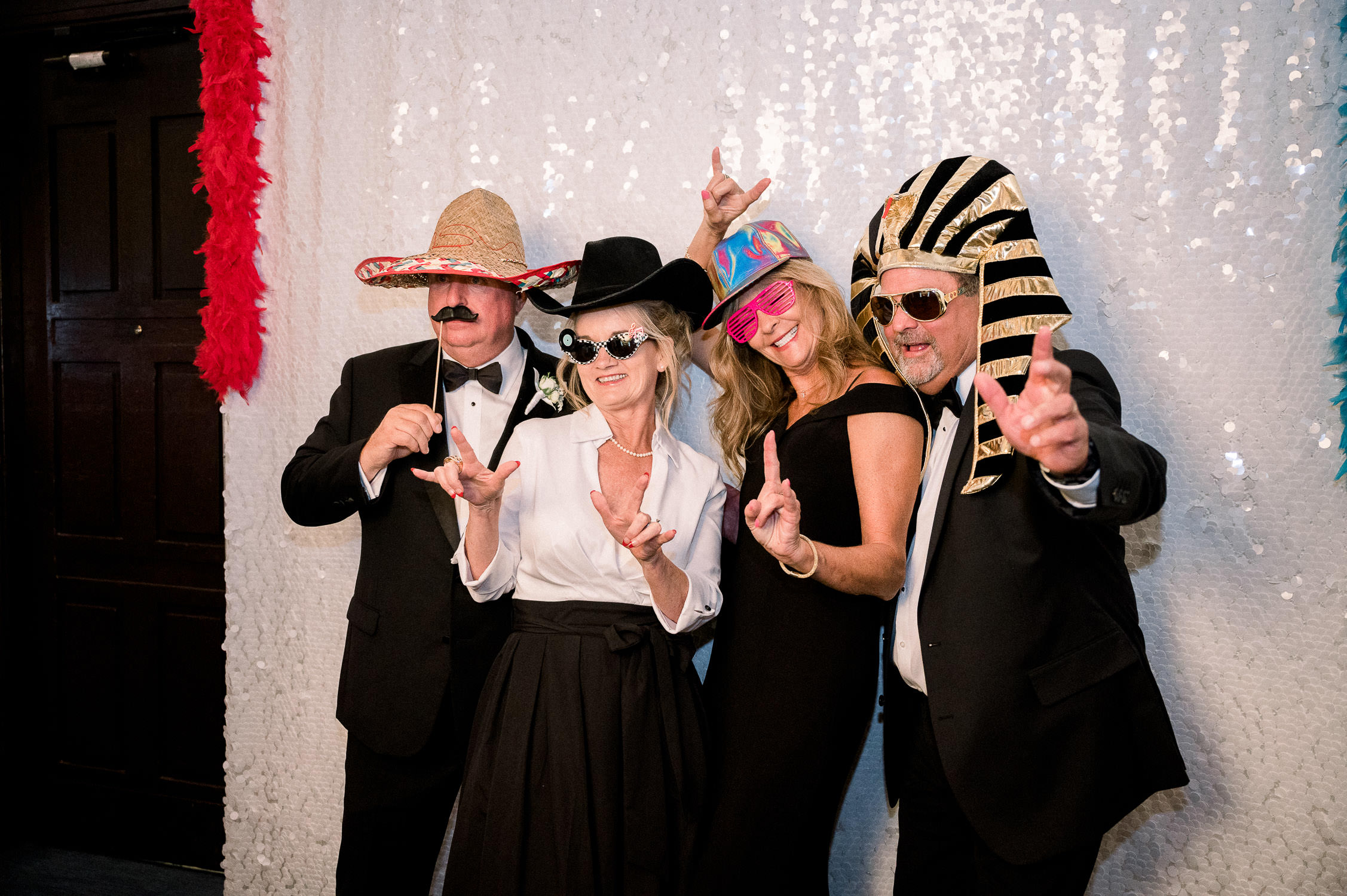 Four guests do silly poses for a photobooth.