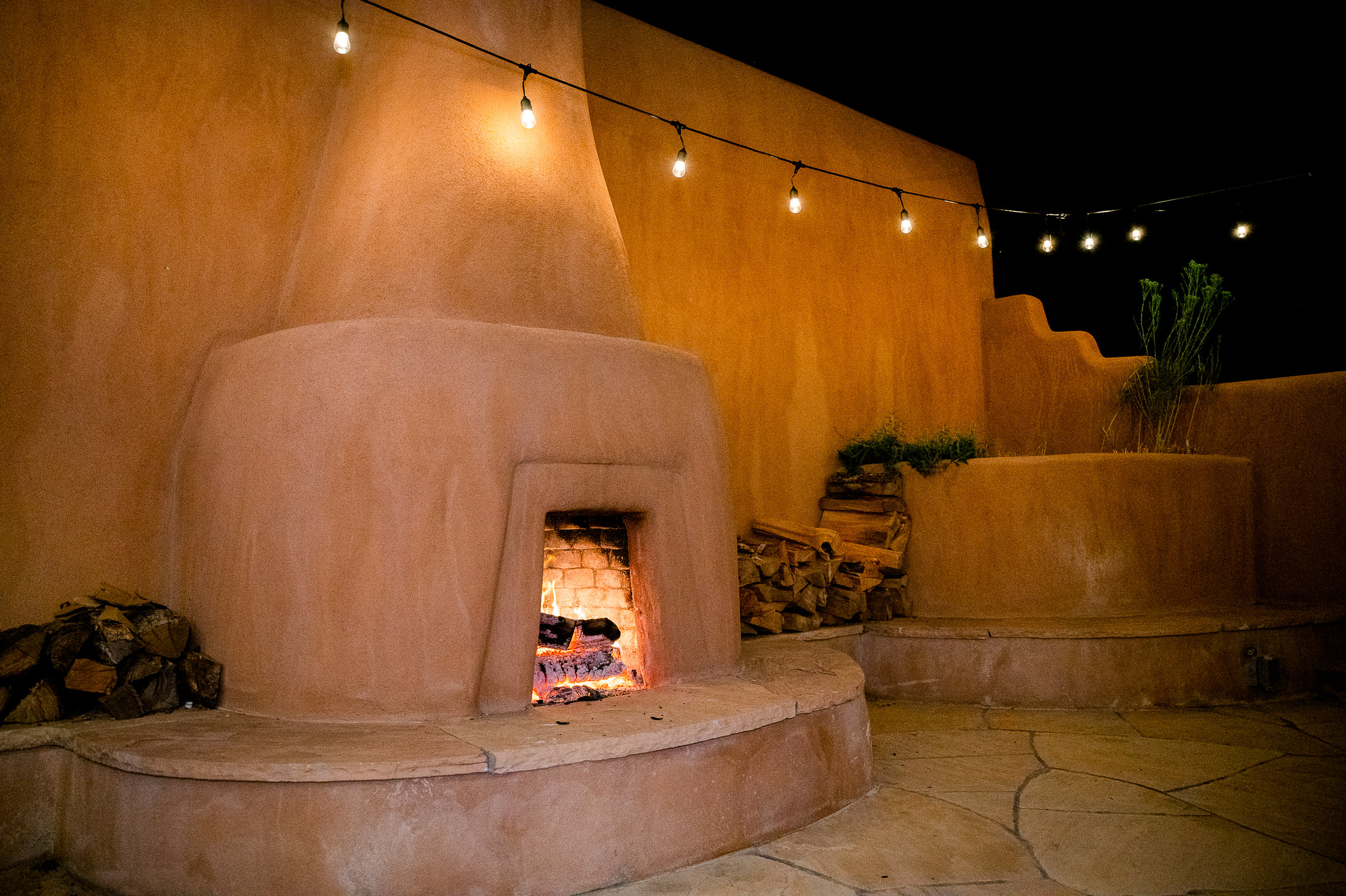 Adobe fireplace with fire.