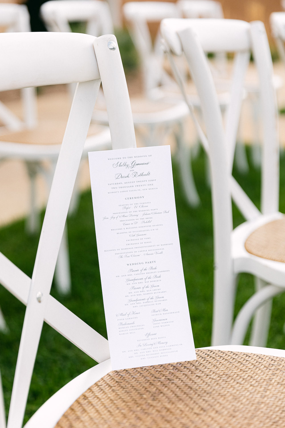 close up on wedding program on a white chair.